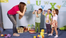 a woman is playing with children in a room
